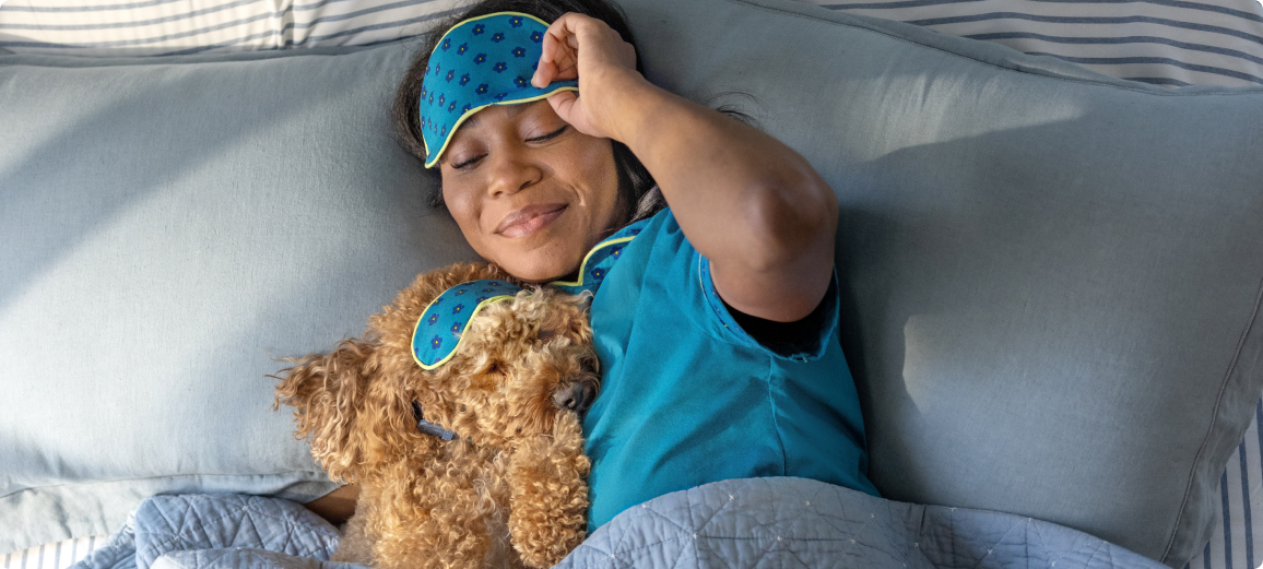 Hund hviler med ejer i sengen